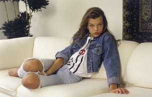 milla jovovich, young girl, long hair, eyes, jeans, vest, jacket, sofa, beauty, young, sexy babe, brunette, model, posing, sitting, sofa, celebrity, personality, actress, hollywood, real celebs wall